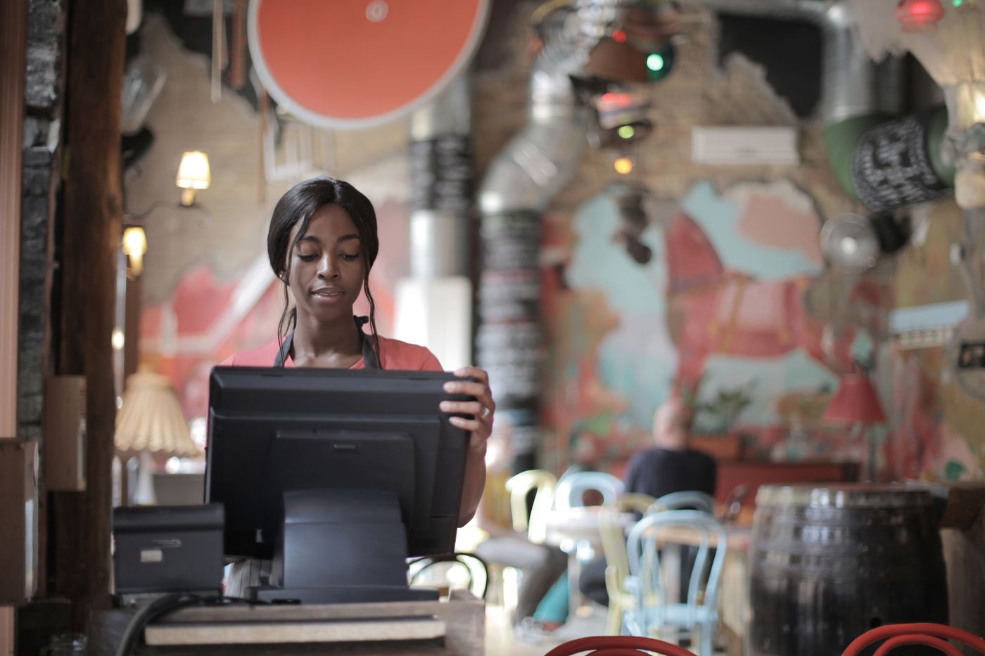 A cashier working the POS at a busy restaurant counter