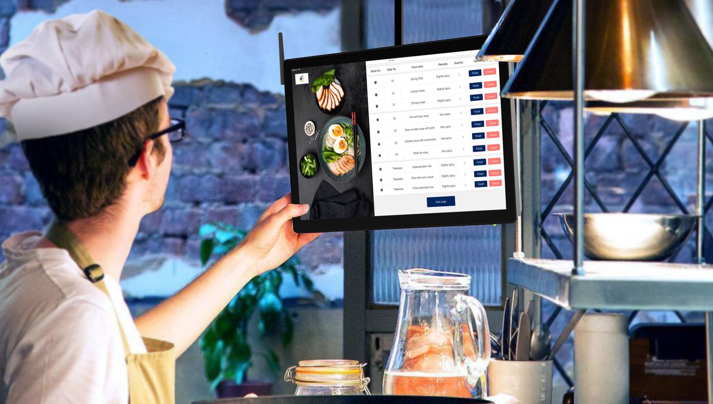 A cook reading incoming orders on a kitchen display screen