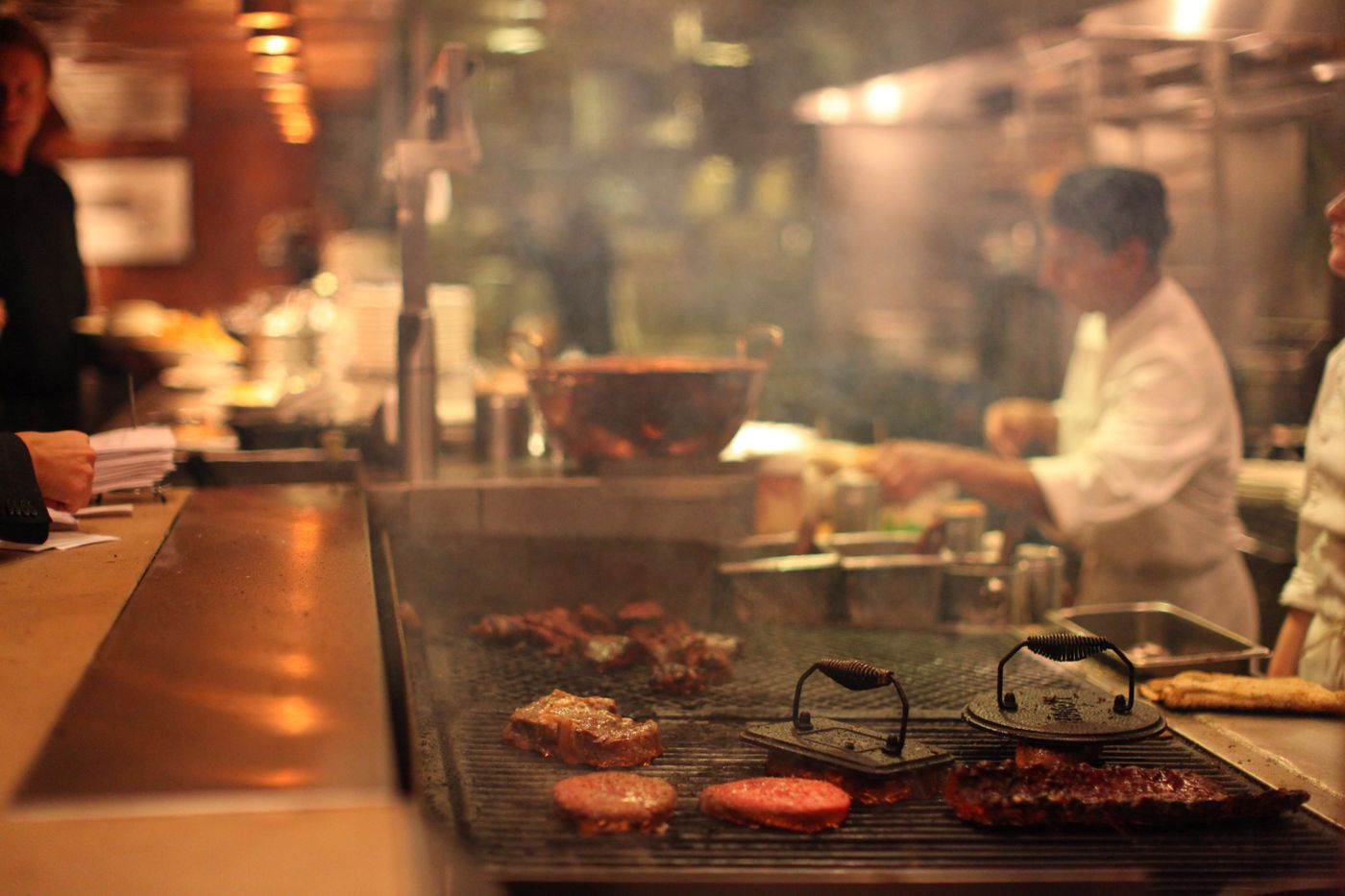 Cooks working the grill in a restaurant kitchen